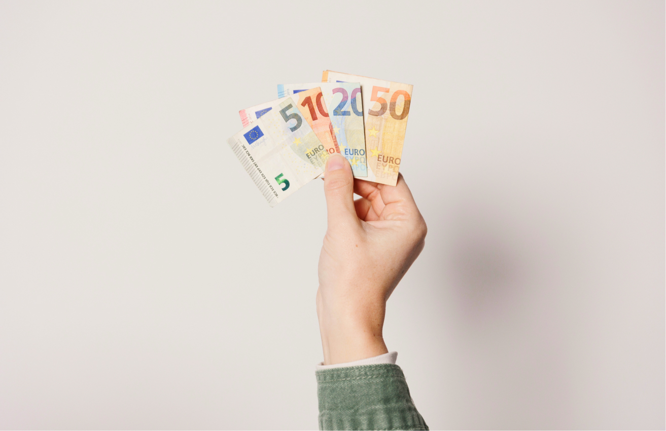 Χέρι που κρατάει χαρτονομίσματα ευρώ